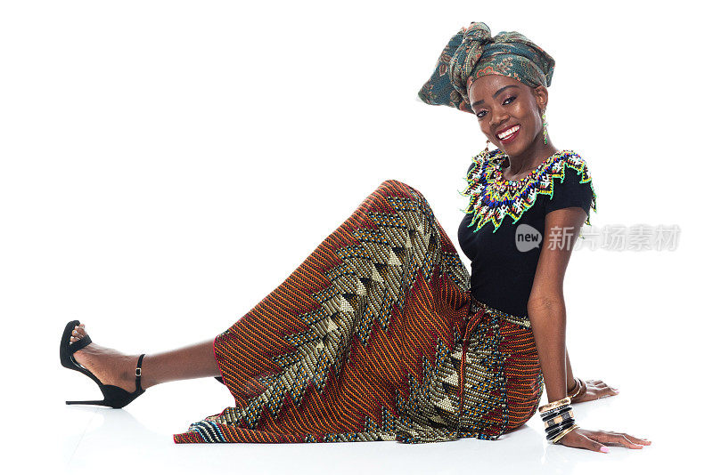 全身/侧面的20-29岁非洲裔/非洲裔年轻女性/女性坐在地板上，戴着头巾/穿着/传统服装，严肃/自信/专注